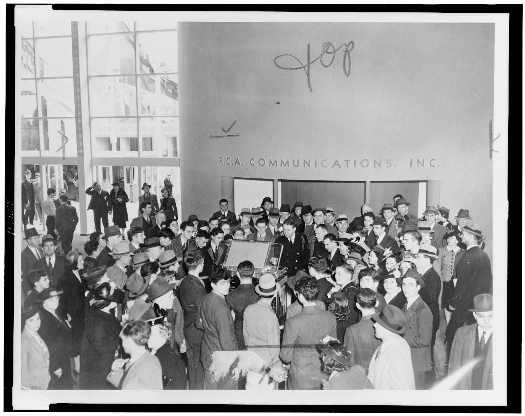 Crowd surrounds television at RCA exhibit at 1939 World's Fair, where RCA sound systems were deployed.