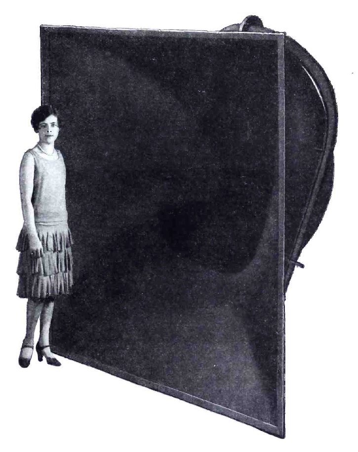 A woman standing beside a large folded horn loudspeaker in an early twentieth-century photograph