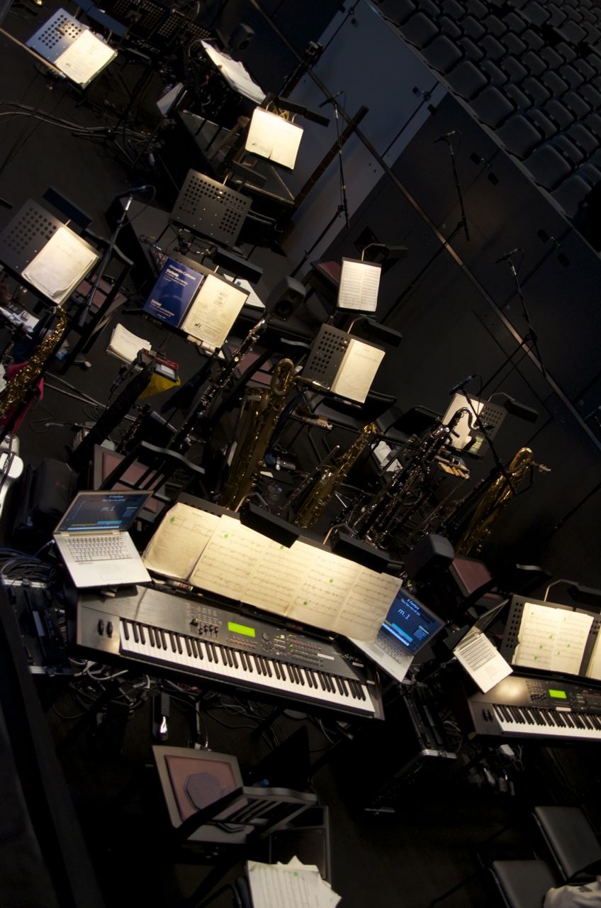 Overhead view of a theatre orchestra pit with music stands and keyboards